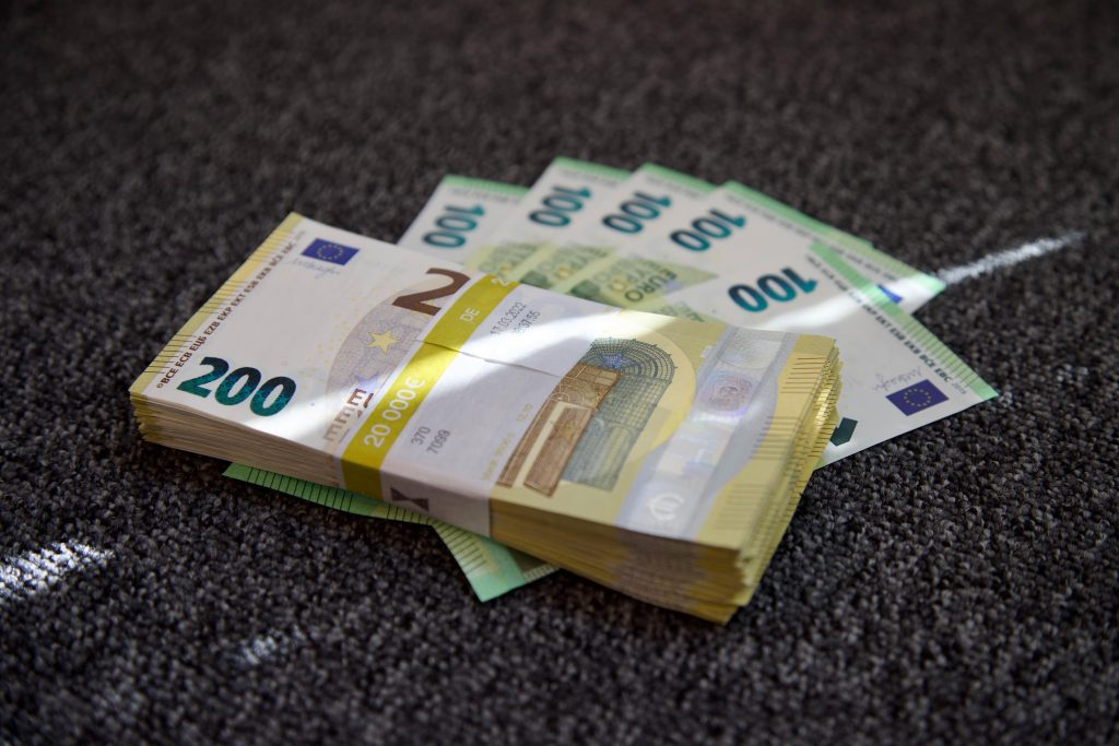 Huismodel met geld symboliserend waarom HELOC dit jaar gevaarlijk kan zijn vanwege stijgende rentetarieven